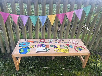 Gemeinsam mit unseren Kindergartenkindern im Alter von 2 bis 6 Jahren beschäftigen wir uns intensiv mit den Kinderrechten. Uns ist wichtig, dass unsere Kinder von Anfang an ihre Rechte kennen und haben diese wunderschöne Bank gestaltet, um auf die Kinderrechte aufmerksam zu machen. In unserem Kindergarten ist jedes Kind wichtig, jede Stimme zählt und wir freuen uns einen wichtigen Beitrag für ein demokratisches Miteinander in der Entwicklung unserer Kinder zu leisten. // © Elisa Schlieker
