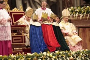 Drei Sternsinger aus Mainz-Gonsenheim brachten beim Neujahrsgottesdienst im Petersdom die Gaben zum Altar. Sie werden von Papst Benedikt gesegnet. Der Papst hat sich in sein Stuhl nach vorne gebeugt um besser mit den drei Sternsingern reden zu können.
