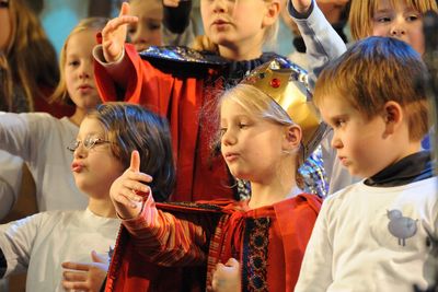 Eine größere Gruppe der Sternsinger singt zusammen ein Lied. Sie unterstreichen den Gesang durch ihre Gestik.