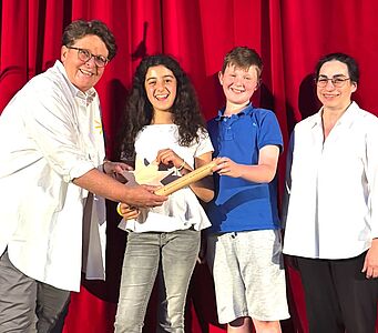 Nach zwei erfolgreichen Benefizkonzert-Abenden übergibt unsere Kollegin Daniela Dicker den Staffelstab an Narin und Jonathan, die Schulsprecherin und den Schulsprecher der Carl-Orff-Grundschule in Berlin. Rechts die stolze Schulleiterin Domenica Acri. // © Anette Aßmuth / Carl-Orff-Schule, Berlin