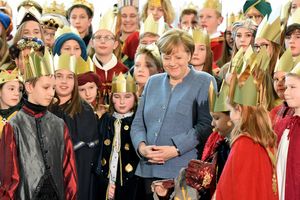 Bundeskanzlerin Angela Merkel in Mitten vieler Sternsinger.