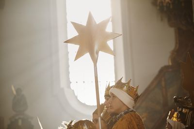 Der Stern der Sternsinger wird durch das Licht das durch ein Kirchenfenster fällt erleuchtet.