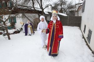 Vier Sternsinger kommen grade von einem erfolgreichen Singen. Sie freuen sich, haben Weihrauch, Kronen und goldene Geschenke mit dabei. sie machen sich auf den Weg durch den tiefen Schnee um noch für andere Menschen zu singen.