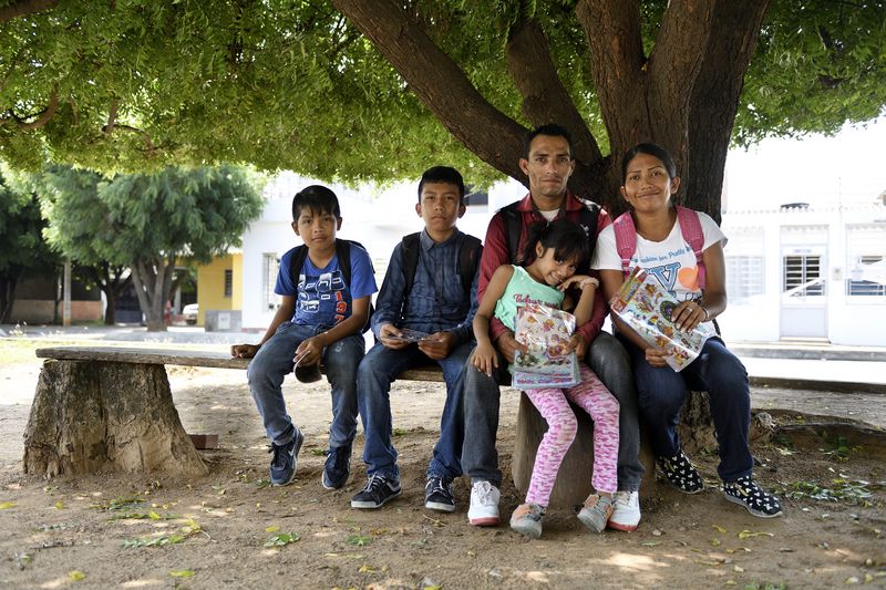 Familienfoto unter einem Baum - Gleimar (8) und Ismael (11) leben seit ihrer Flucht aus Venezuela mit ihren Eltern Maria Sosa (31) und Antonio Carpio (30) und den Geschwistern Manuel (13) und Yannovis (2) in Cúcuta, Departamento Norte de Santander, Kolumbien; Foto: Florian Kopp