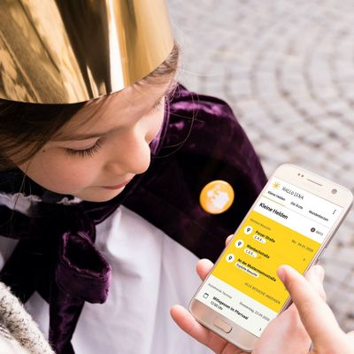 Sternsinger schauen zusammen auf die mobile Sternsinger-App