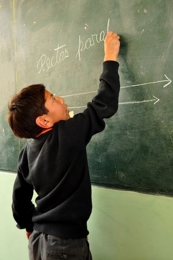 Jonathan schreibt fleißig an die Tafel in der Schule.