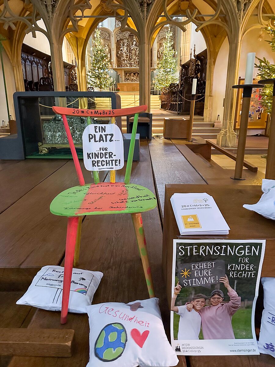 Dieser Stuhl wurde im Rahmen unserer Sternsingervorbereitungen von den Breisacher Sternsingern gestaltet. Durch seine bunte Farbgestaltung soll er auffallen und so auf die wichtigsten Kinderrechte aufmerksam machen, die die Kinder und Jugendlichen auf dem Stuhl notiert haben. 
Darüber hinaus hat jede Sternsingerin und jeder Sternsinger ein eigenes Sitzkissen bemalt. Darauf ist zu sehen, welche Kinderrechte den Kindern besonders wichtig sind. 
Im Rahmen des Sternsingergottesdienstes wurden diese vorgestellt und die ganze Gemeinde dazu aufgefordert, die Stimme für Kinderrechte zu erheben und die Aktion der Sternsinger zu unterstützen. // © Alexandra Hau