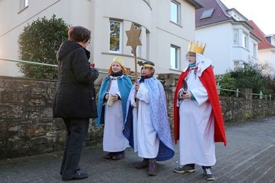 Leni (8), Pia (7) und Joris singen auf der Straﬂe vor einer Passantin auf ihrem Weg durch die Gemeinde. 