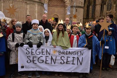 Susanne Kiefer, BDKJ-Diözesanvorsitzende, Prälat Dr. Klaus Krämer, Präsident des Kindermissionswerks ,Die Sternsinger', Dr. Stephan Ackermann, Bischof von Trier, und Pfarrer Dirk Bingener, Bundespräses des Bundes der Deutschen Katholischen Jugend freuen sich gemeinsam mit den unzähligen Sternsinger über die gelungene Eröffnungsfeier in Trier. Die erste Reihe trägt ein Banner mit dem Slogan der Sternsinger. Dieser lautet Segen bringen, Segen sein. 