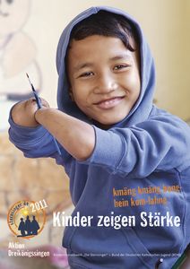 Das Plakat zur Aktion Dreikönigssingen 2011.  Abgebildet ist ein Junge in einem blauen Kapuzenpullover. Der Junge lächelt und hat die Ärmel des Pullovers bis der die Ellbogen hoch gekrempelt. Der junge hat keine Hände mehr. Seine Arme hören auf halbem Weg zwischen Ellbogen und Handgelenk auf. Mit den Enden seiner Arme hält der Junge einen Pinsel fest um mit diesem Pinsel zu malen. In der Fußzeile des Plakats steht Kinder zeigen Stärke. Auf Khmer kmäng kmäng bong- nein kam- lahng. Auch das bedeutet Kinder zeigen Stärke. Unten links in der Ecke das Plakats ist das Logo der Sternsinger und der Schriftzug Aktion Dreikönigssingen.   