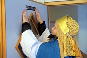 Leni (8) heftet den Segen an die Tuer einer Wohngruppe im Wohn- und Pflegzentrum Paulusheim Osnabrueck. 