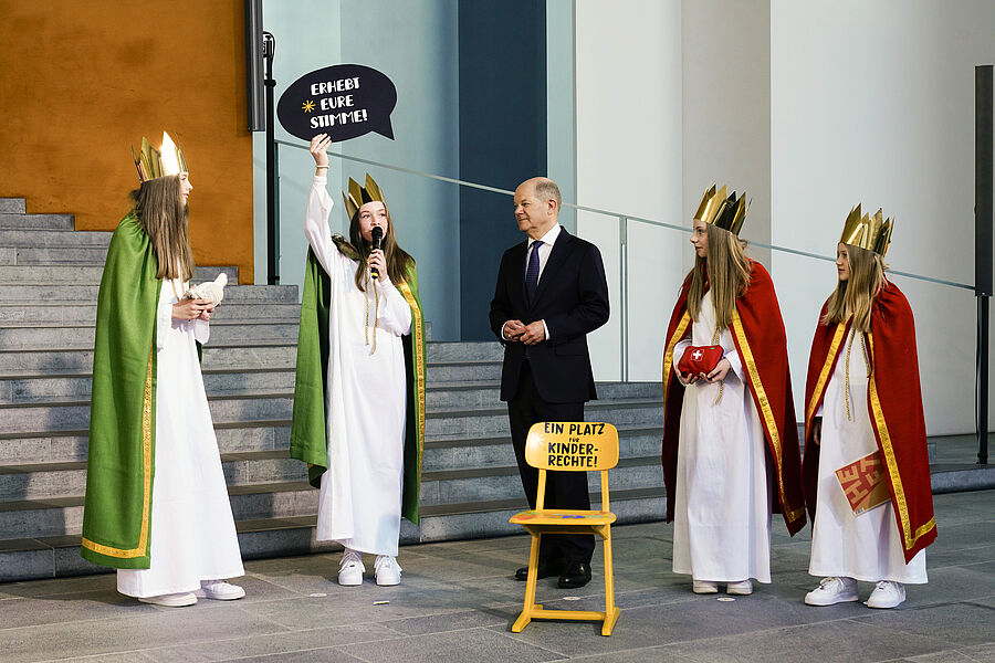 Archivnummer: KMW_8916 „Erhebt eure Stimme! – Sternsingen für Kinderrechte“ lautet das Motto der 67. Aktion Dreikönigssingen. Die Sternsingerinnen Maleen (13), Paula (13), Josefin (13) und Anna (10) aus dem pastoralen Raum Rietberg (Erzbistum Paderborn) stellten dem Bundeskanzler das Motto vor. Zudem überreichten sie ihm einen gelben Stuhl, der symbolisch einen Platz für Kinderrechte einfordert. // © Friedrich Stark / Kindermissionswerk
