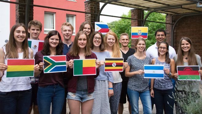 Gruppenbild von jungen Erwachsenen mit Länderflaggen in den Händen