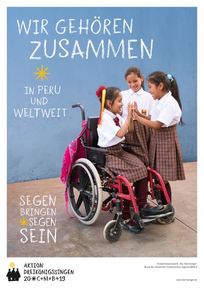 Das Plakat zur Aktion Dreikönigssingen 2019. Der Leitspruch der Aktion lautet Wir gehören zusammen  in Peru und weltweit. Unten links in der Ecke steht Segen bringen, Segen sein. Auf dem Plakat sind drei Mädchen zu sehen die miteinander spielen. Das besondere ist, dass eines der Mädchen im Rollstuhl sitzt. Die beiden anderen Mädchen stehen ei ihr und spielen ein Klatschspiel mit ihr. Alle drei haben spaß zusammen. Die Gehbehinderung des Mädchens im Rollstuhl spielt für die anderen Mädchen keine Rolle. Die Kinder im Bild haben die gleiche Schuluniform an und gehen auf die selbe Schule. Die Schuluniform besteht aus einer weißen Bluse und einem rot karierten Rock. 