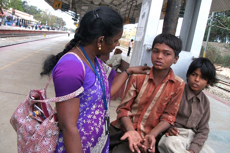 Eine Streetworkerin spricht mit Straßenkindern und kümmert sich um sie.