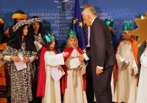 Der Präsident des EU- Parlaments, Jerzy Buzek, begrüßt die Sternsinger im EU- Parlament. Die Sternsinger tragen rote Umhänge und tragen Kronen. der Präsident Jerzy Buzek gibt den Sternsinger zur Begrüßung die Hand.