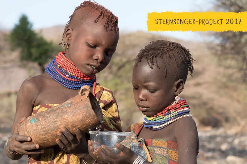 Aweed giesst ihrer Schwester Musungu Wasser ein, Turkana, Kenia, 2/2016