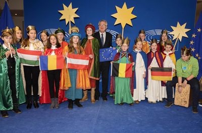 Der deutsche EU- Vizepräsident Rainer Wieland empfängt zwanzig Sternsinger aus sechs europäischen Ländern. Die Sternsinger kommen aus unter anderem aus Ungarn, Rumänien und Österreich. Der EU- Vizepräsident Rainer Wieland steht im Zentrum er Sternsinger. Die Sternsinger halten verschiedene Nationalflaggen. Rainer Wieland hält die Flagge der Europäischen Union. Ein Sternsinger sitzt auf einem Cajon.