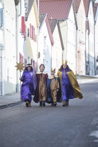 Die vierköpfige Sternsingergruppe geht in Eichstätt durch die Straßen und ist auf dem Weg zum nächsten Auftritt. Die Gruppe hat prachtvoll Gewänder und Kronen an. Dazu tragen sie auch noch den Stern an einem langen Stock mit sich. 