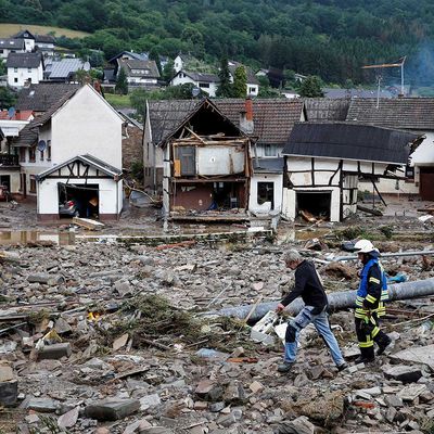 Hochwasser-Katastrophe in Westdeutschland Ein Mann und ein Feuerwehrmann gehen nach heftigen Regenfällen im Ort Schuld am 15. Juli 2021 durch Trümmer.