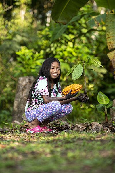 Valeria Fernandéz Ramos (10) mit einer Kakao-Bohne / einem Kakao-Setzling, Santa Sofía, Letícia, Kolumbien 