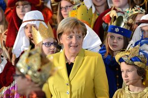 Bundeskanzlerin inmitten vieler Sternsinger die zu Besuch im Bundeskanzleramt sind.