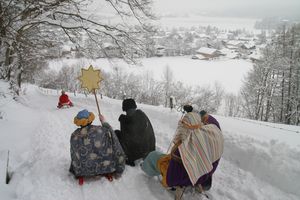 Mit dem Schlitten geht es für diese Sternsinger zum nächsten Haus. Über tiefverschneite Felder sausen sie ins nächste Dorf um auch dort den Menschen dennSegen zu bringen. 