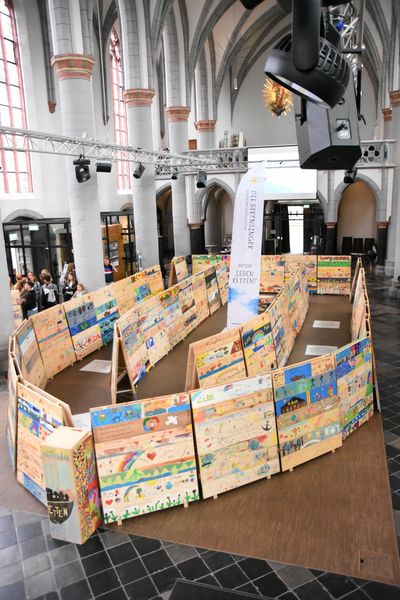 Kinder wollen "Leben retten!" - ein symbolisches Rettungsboot aus rund 600 bunten Planken in der Aachener Citykirche. 