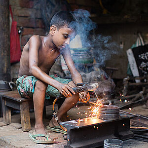 Jitu (9) bei seiner Arbeit in einer Metallwerkstatt. Um seine Familie zu versorgen, hat Jitu bereits früh angefangen zu arbeiten. 
