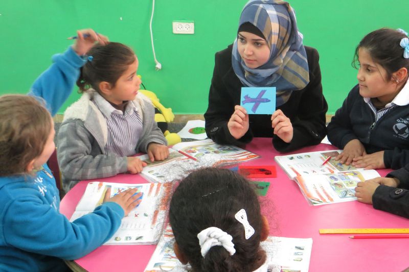 Vier Kinder beim Unterricht mit einer Lehrerin.