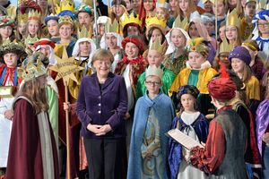 Die Bundekanzlerin inmitten vieler Sternsinger. Die Sternsinger bereiten sich grade darauf vor los zu singen.