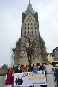 Bürgermeister von Paderborn Michael Dreier, Pfarrer Simon Rapp, Bundespräses des Bundes der Deutschen Katholischen Jugend, Prälat Dr. Klaus Krämer, Präsident des Kindermissionswerks 'Die Sternsinger' und die Sternsinger aus der Gemeinde St. Johannes Baptist in Nieheim-Entrup stehen vor dem Generalvikariat des Erzbistums Paderborn. Sie halten dasBanner mit dem Slogan Segen bringen, Segen sein.