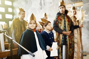 7_Sternsingen in Dillingen n der Kirche: Man sieht Sternsinger mit Kronen und festlichen Umhängen. Ein Kind guckt stolz in die Kamrea. I