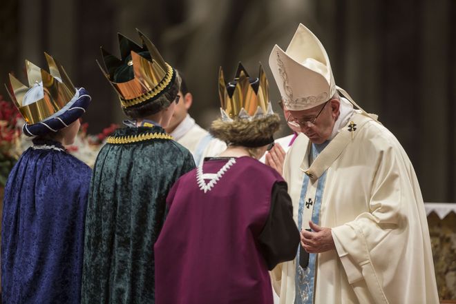 Drei Sternsinger mit Umhängen und glänzenden Kronen stehen ganz nah bei Papst Franziskus. Die Sternsinger sind Teil der Messe im Petersdom und der Papst hat sich bei Ihnen für ihren Einsatz bedankt.