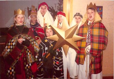 Ein Foto von 1967. Sieben Sternsinger Singen und drei von ihnen spielen auch noch Blockflöte. Alle sind festlich gekleidet und tragen goldenen Kronen