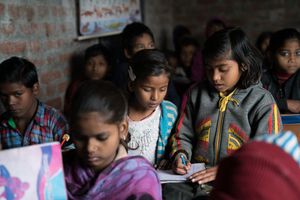 Reportage_Neetu_Aktuell Besuch bei Neetu (braun-weiß gestreifte Jacke) und Jyoti (blau-weiß gestreifte Jacke), die in der indischen Stadt Firozabad Armreifen zusammenschmelzen. Dank der Hilfe der Sternsinger können die beiden nun auch zur Schule gehen. Die Vikas-Stiftung hat außerdem ein Kinderparlament in ihrem Stadtteil in Firozabad ins Leben gerufen, das die beiden Mädchen besuchen.