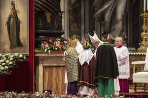 Drei Sternsinger stehen vor Papst Franziskus. Sie haben die traditionellen Gewänder an. Die Sternsinger haben an der Gabenprozession teilgenommen. Sie stehen direkt vor dem Papst. 