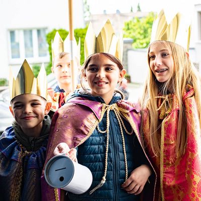 Sternsinger mit Spendendose an der Haustür