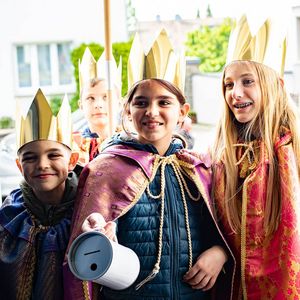 Sternsinger mit Spendendose an der Haustür