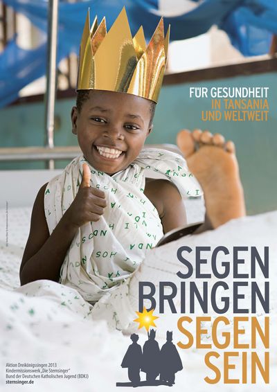 Das Plakat zur Aktion Dreikönigssingen 2013 für das Beispielland Tansania. Der Leitspruch der Aktion lautet Segen bringen, Segen sein. Die Forderung lautet Für Gesundheit in Tansania und Weltweit. Auf dem Plakat abgebildet ist ein Junge aus Tansania. Der Junge liegt in einem Krankenbett im Krankenhaus und hat eine Decke um seinen Oberkörper gewickelt. Sein linkes Bein liegt gestreckt in einer Schiene. Der Junge hat eine glänzende goldene Krone auf und sieht, obwohl er verletzt im Krankenhaus ist, glücklich aus.Er hält als Ausdruck seiner Freude den Daumen nach oben in die Kamera. 